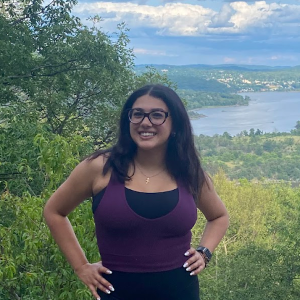 A college student standing on a mountain by the river
